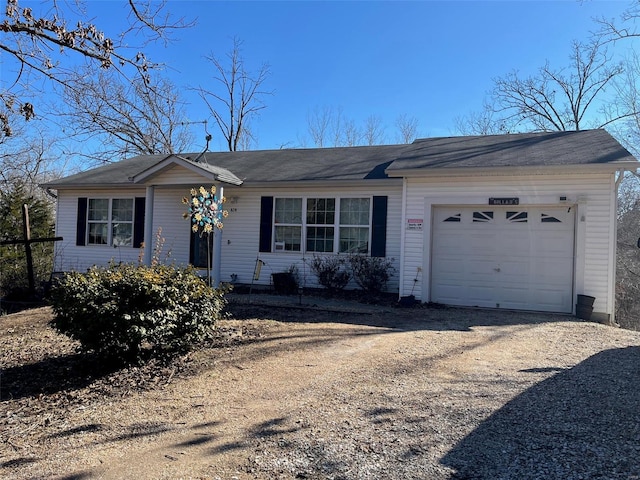 single story home featuring dirt driveway and a garage