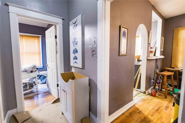 hall featuring light wood-type flooring and baseboards