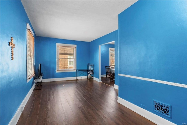 empty room featuring visible vents, baseboards, and wood finished floors