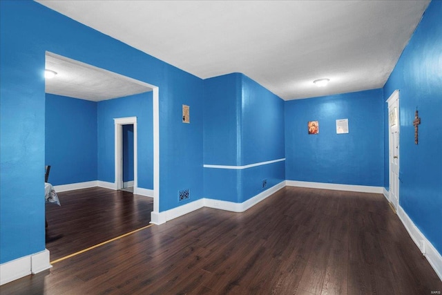 unfurnished room featuring baseboards and wood finished floors