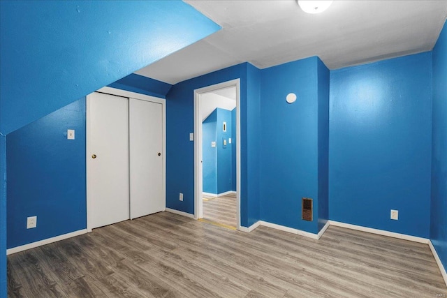 bonus room featuring visible vents, vaulted ceiling, baseboards, and wood finished floors