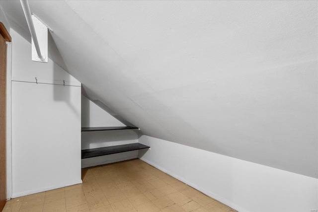 interior space featuring vaulted ceiling and tile patterned floors