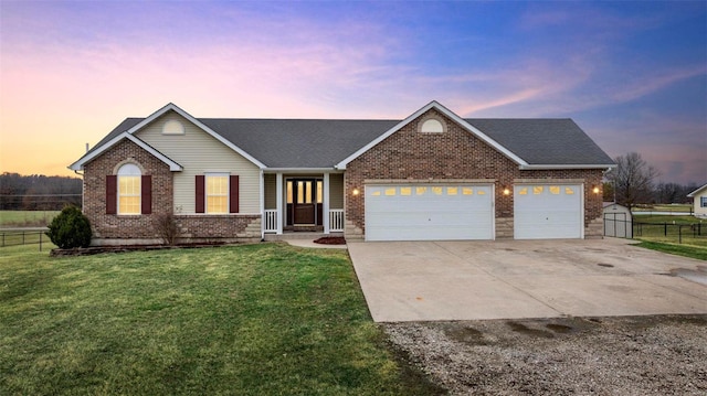 ranch-style house featuring a garage, a lawn, concrete driveway, fence, and brick siding