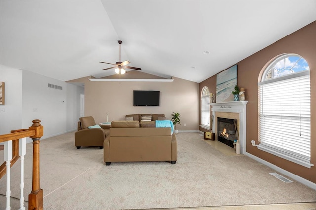 living room featuring light carpet, a fireplace with flush hearth, visible vents, and vaulted ceiling