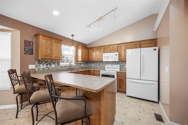 kitchen featuring a peninsula, white appliances, visible vents, and vaulted ceiling