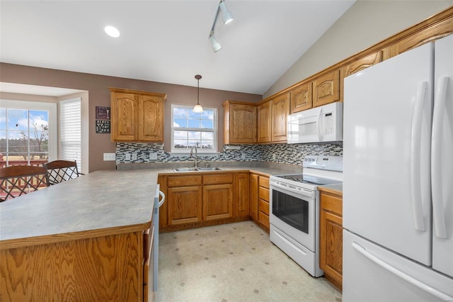 kitchen featuring white appliances, lofted ceiling, brown cabinets, light floors, and a sink