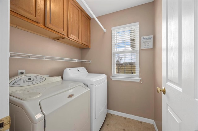 laundry area featuring cabinet space, washer and clothes dryer, and baseboards