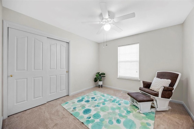 living area with light carpet, ceiling fan, and baseboards