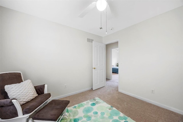 sitting room with light carpet, baseboards, visible vents, and a ceiling fan