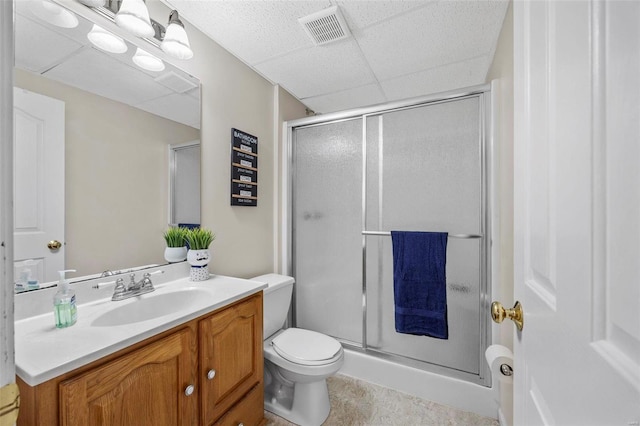 bathroom with visible vents, toilet, vanity, a paneled ceiling, and a shower stall