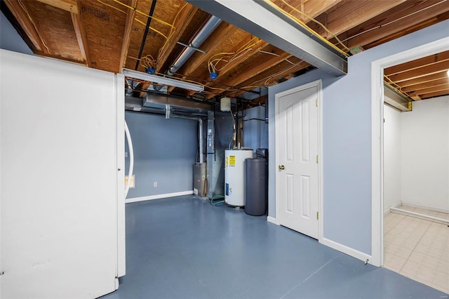 unfinished basement featuring freestanding refrigerator, water heater, and baseboards