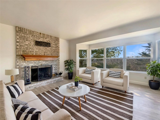 living room with a fireplace, baseboards, and wood finished floors