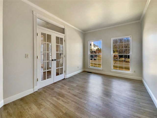 unfurnished room with french doors, crown molding, baseboards, and wood finished floors