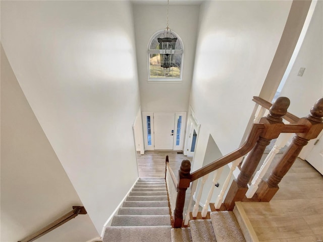 staircase featuring a high ceiling and wood finished floors