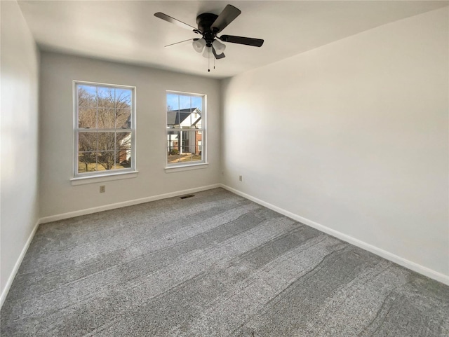 carpeted empty room featuring visible vents, baseboards, and a ceiling fan