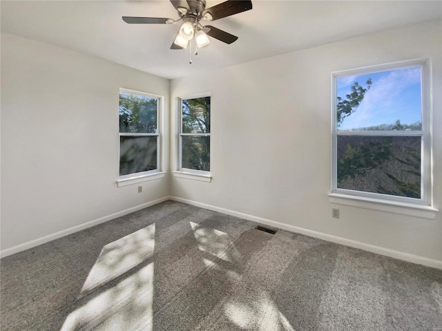 unfurnished room with ceiling fan, carpet, visible vents, and baseboards