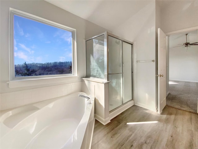 full bathroom with a bath, a stall shower, a ceiling fan, and wood finished floors