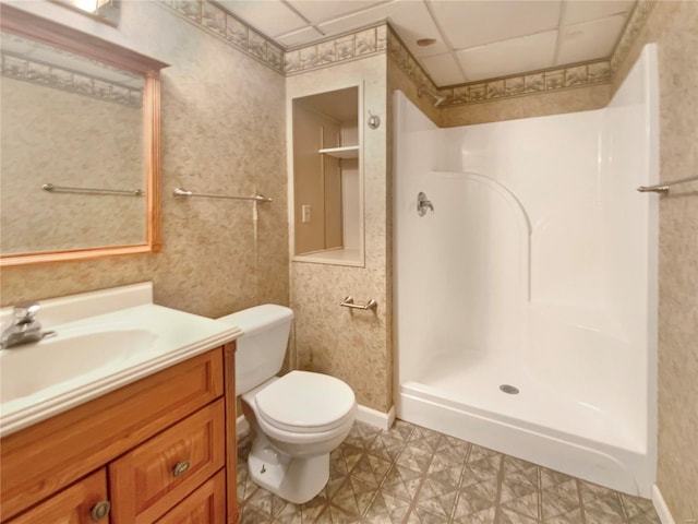 bathroom with a shower, tile patterned floors, toilet, vanity, and wallpapered walls