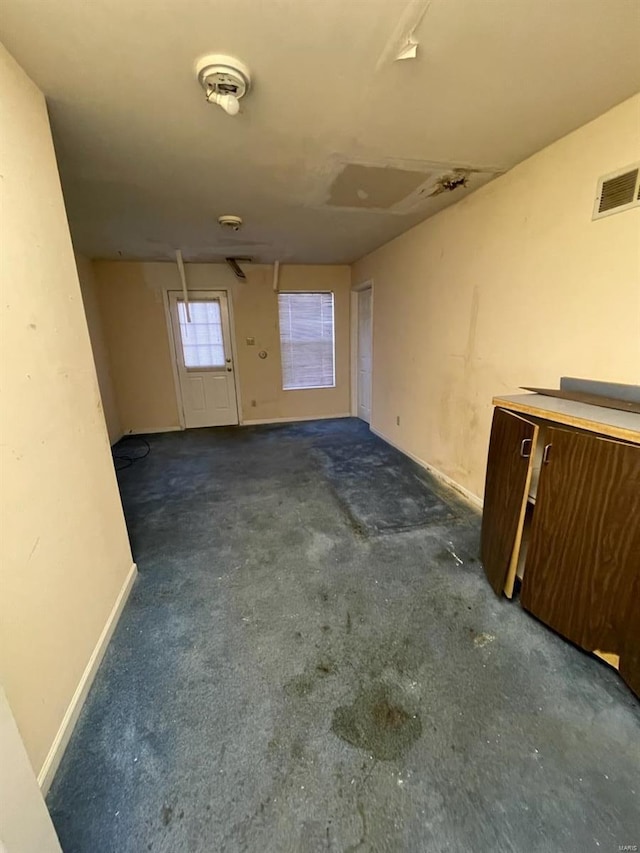 carpeted empty room with visible vents and baseboards