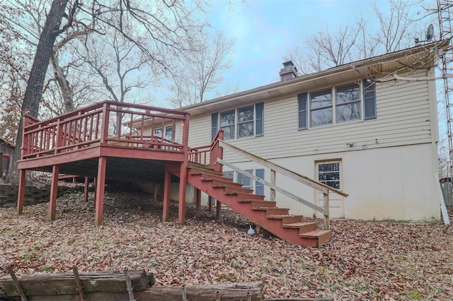 back of house featuring stairway, a chimney, and a deck