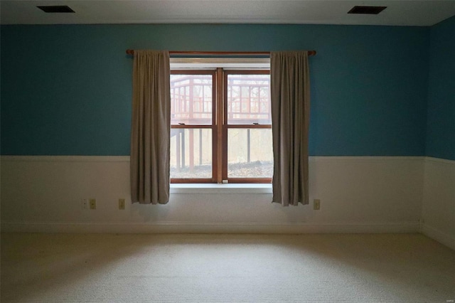 unfurnished room with visible vents and carpet floors