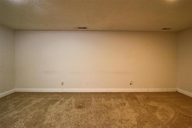 empty room with visible vents, baseboards, and carpet flooring