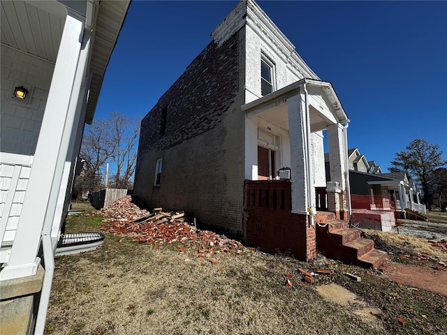 view of home's exterior featuring a porch and brick siding