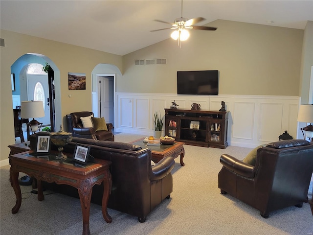 living room with carpet, visible vents, and arched walkways