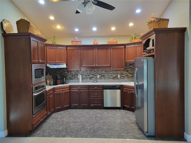 kitchen with appliances with stainless steel finishes, backsplash, light countertops, and under cabinet range hood