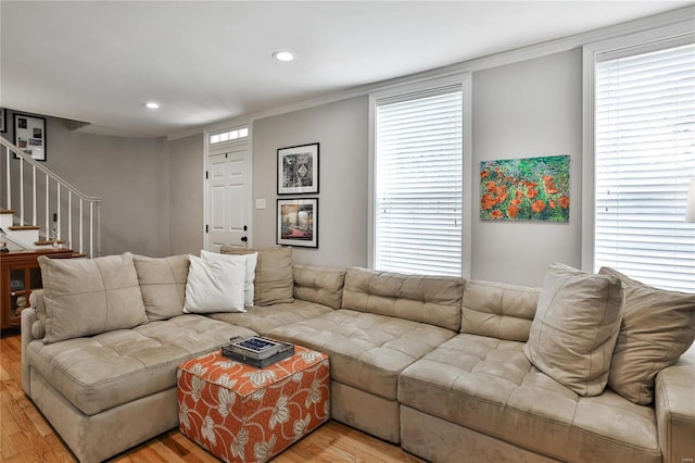 living room featuring plenty of natural light, stairway, and wood finished floors