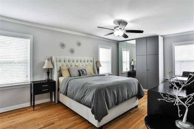 bedroom with light wood-style floors, ceiling fan, baseboards, and crown molding