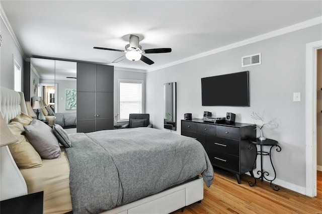 bedroom with light wood-type flooring, visible vents, and crown molding