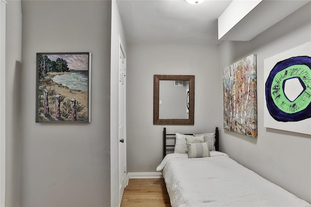 bedroom with baseboards and wood finished floors