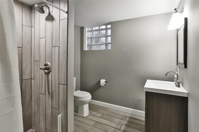 full bathroom featuring baseboards, toilet, a shower with curtain, wood tiled floor, and vanity