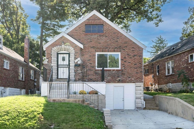 view of front facade featuring cooling unit, brick siding, and a front lawn