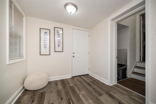 entryway with stairs, wood finished floors, and baseboards