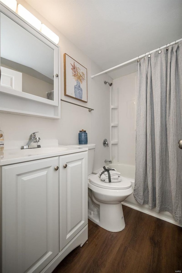 bathroom featuring shower / bath combination with curtain, vanity, toilet, and wood finished floors