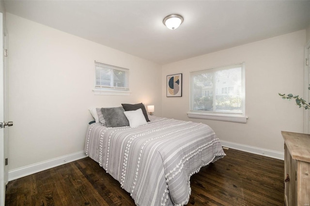 bedroom featuring baseboards and dark wood-type flooring