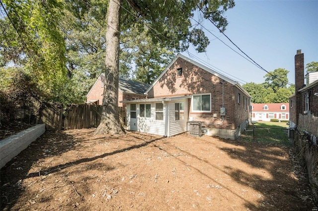 back of property with brick siding and fence