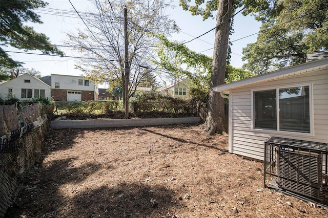 view of yard with central AC unit and fence