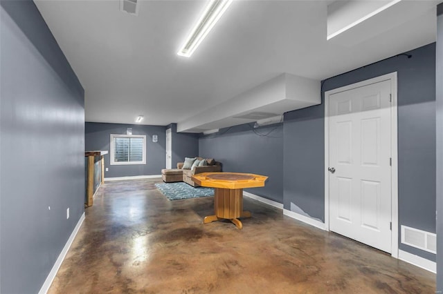 interior space featuring baseboards, visible vents, and concrete flooring