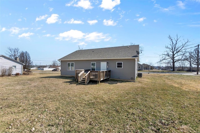 rear view of property featuring a yard and a deck