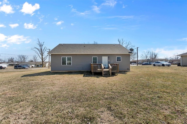 back of property featuring a lawn and a wooden deck