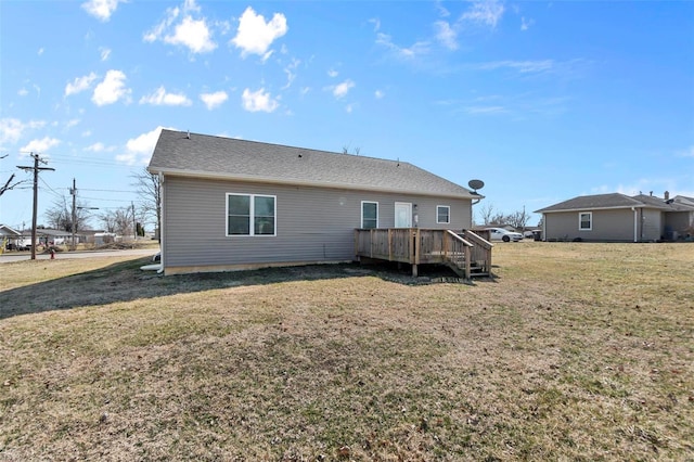 back of property featuring a deck and a lawn