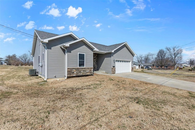 view of front of house with central air condition unit, an attached garage, stone siding, driveway, and a front lawn