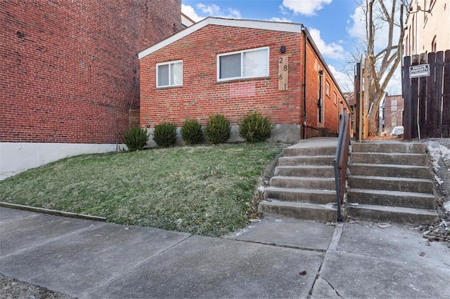 view of home's exterior featuring a lawn and brick siding