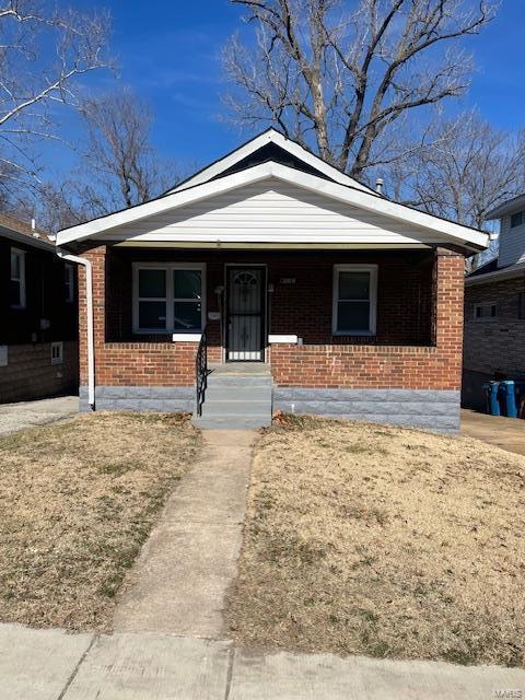 bungalow-style home featuring brick siding and a porch