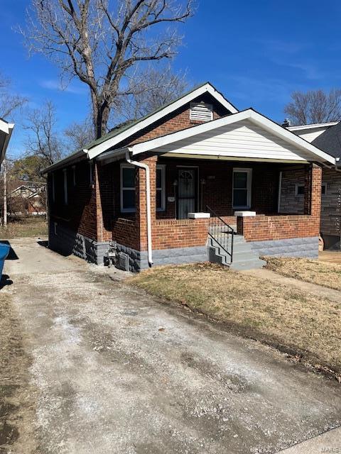 view of front of home featuring a porch and brick siding