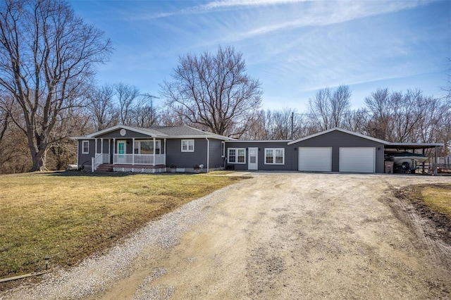 ranch-style home with driveway, covered porch, and a front yard