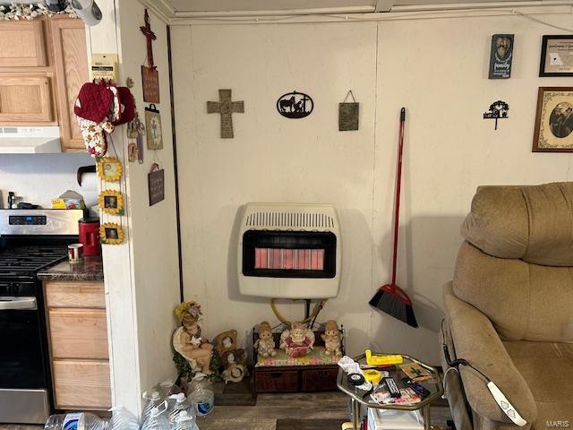 interior space with heating unit, gas range, and extractor fan